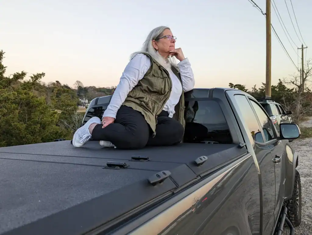 Mary Ellen Kundrat, founder of Tools to Thrive Today, sitting outdoors at sunset contemplating her next chapter